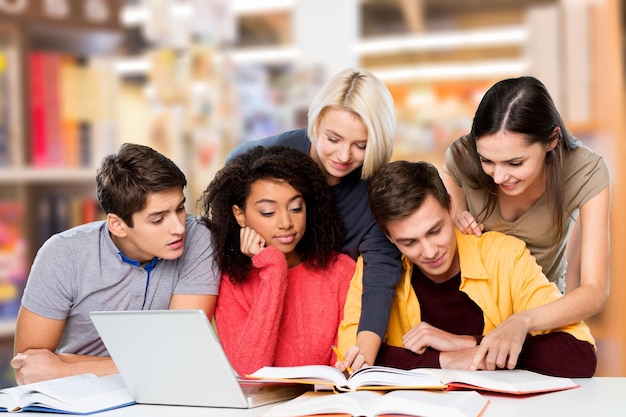 Young students studying with laptop and books