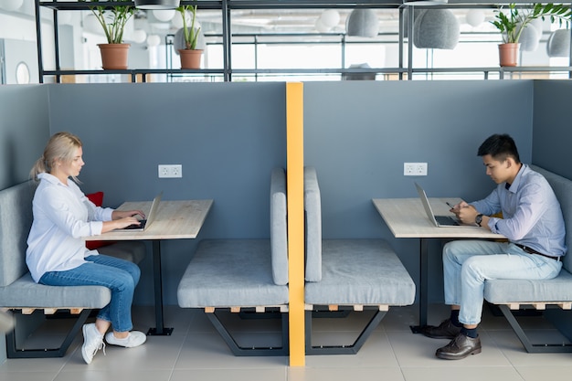 Young students using wireless technology in cafe