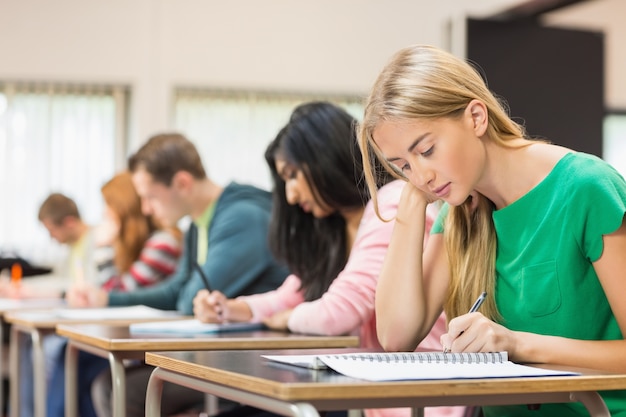 Giovani studenti che scrivono le note in aula