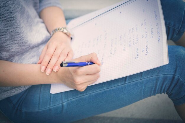 Young students writing notes into notebook