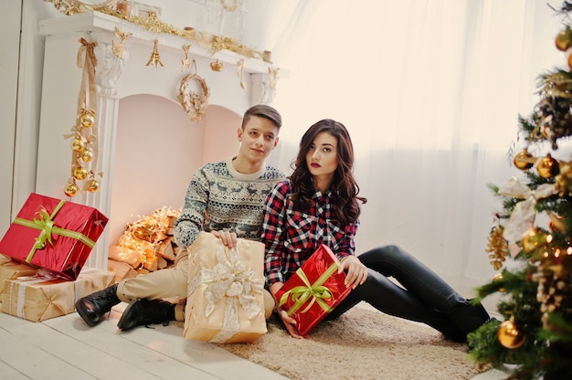 Young stylish couple with Christmas gifts and New Year decoration