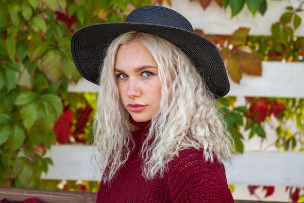 Young stylish girl in a burgundy sweater in an autumn park