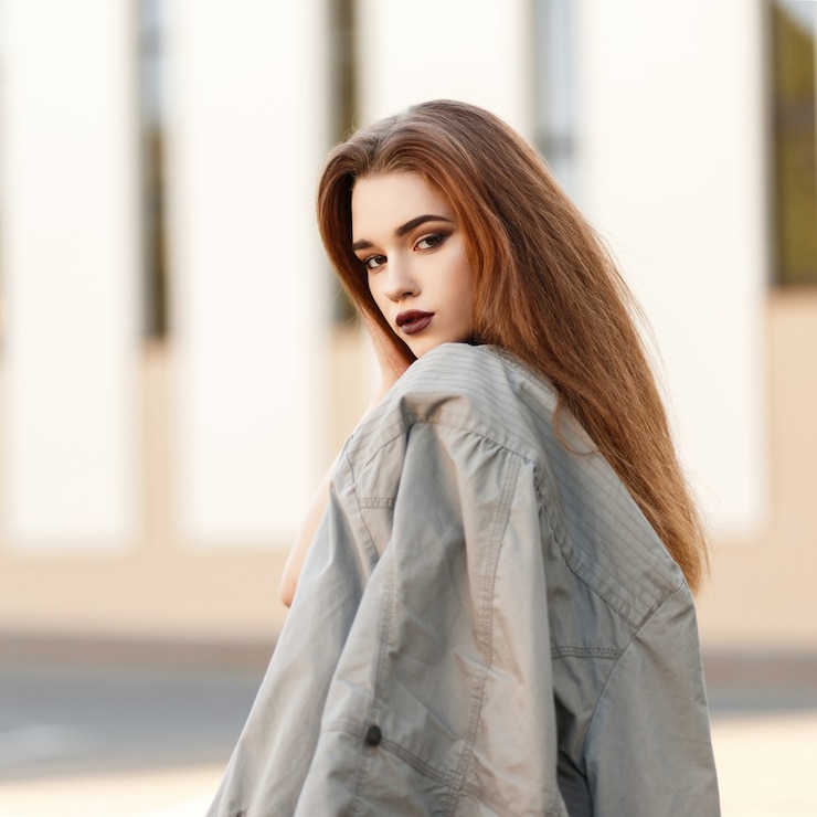 Фотография молодая стильная девушка-модель с курткой на улице