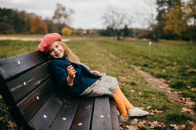 A young stylish girl posing on the bench