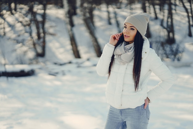 young and stylish girl snadning in a winter snowy park