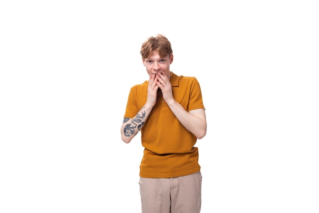 Photo young stylish guy with red hair is dressed in a mustardcolored tshirt