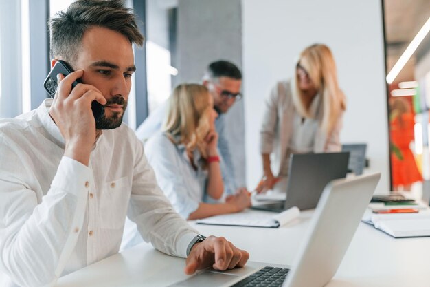 Young stylish man is working Group of professional business people is in the office