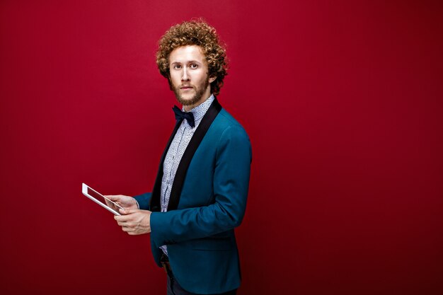 Young stylish man in suit with tablet