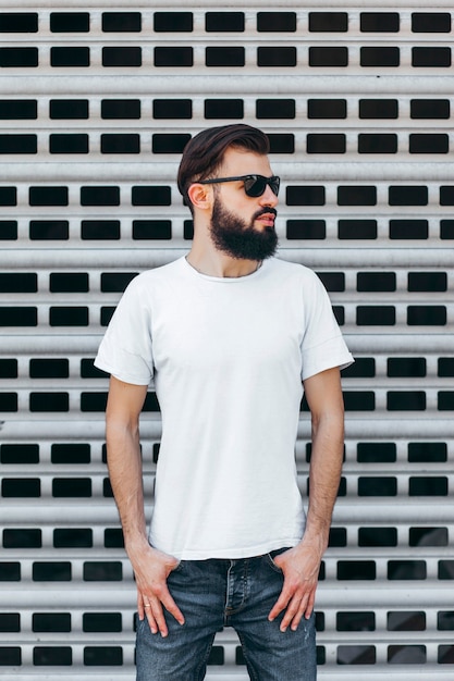 A young stylish man with a beard in a white Tshirt and glasses Street photo