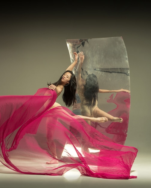 거울이 있는 갈색의 젊고 세련된 현대 발레 댄서