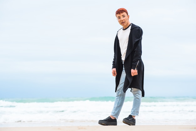 Young stylish weared man is posing on a beach