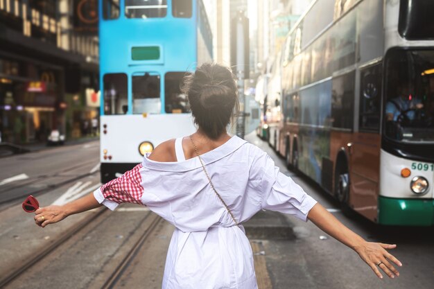 Молодая стильная женщина гуляет по улице города Гонконг