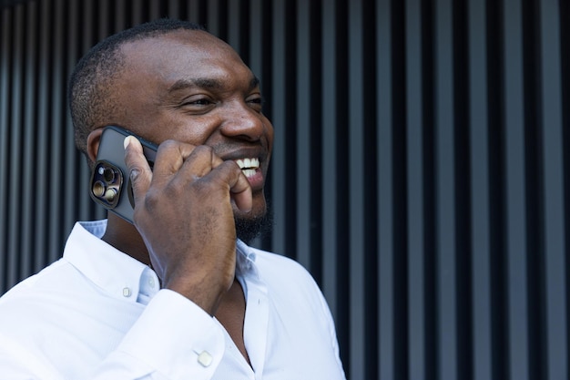 A young successful AfricanAmerican man with a notebook and a smartphone in his hands