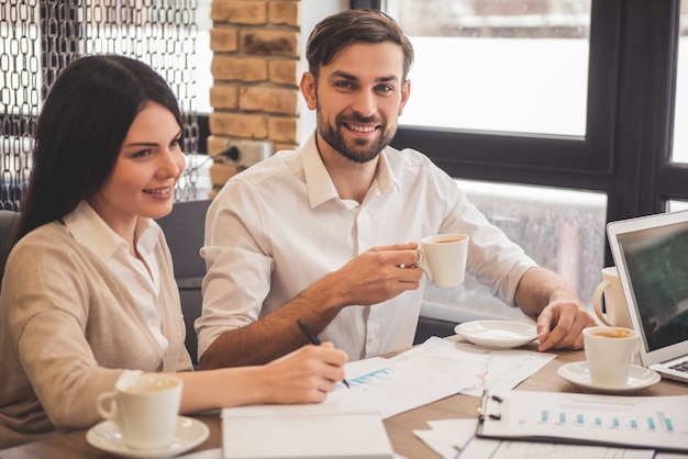 Young successful business couple is using a laptop