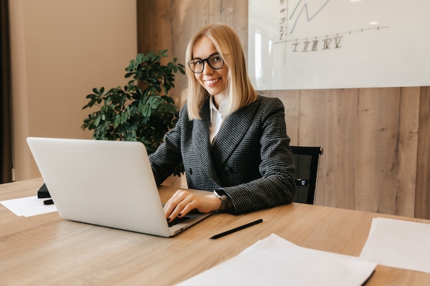 A young successful business woman sits at a workplace in her office as a company director. Business center worker.