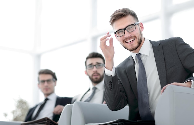 Young successful businessman on background of office