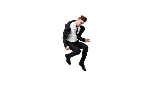 Фото Молодой успешный бизнесмен в костюме радуется прыжкам на белом фоне
