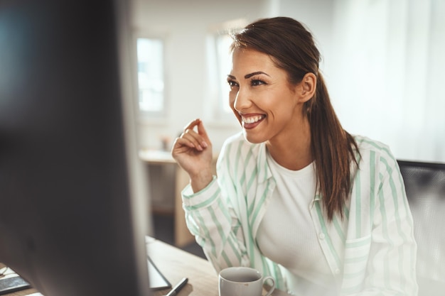 A young successful female designer is working on a new project on computer in the office.