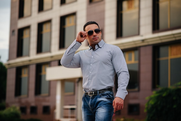 Young successful man near an office building. Business