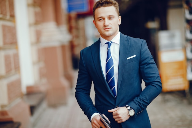 A young and successful man stands in a blue suit