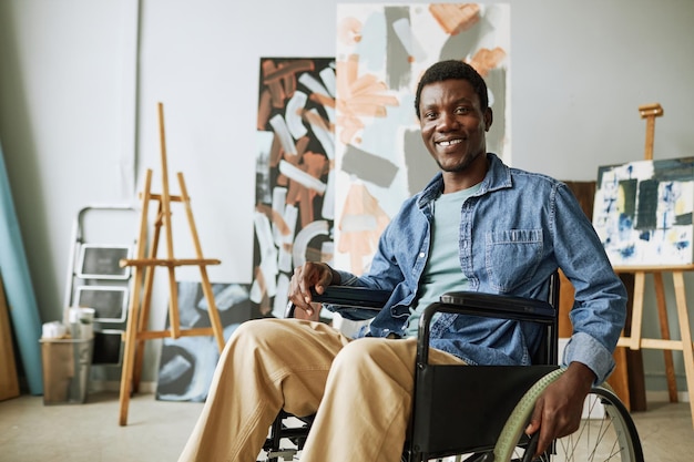 Young successful painter in casualwear sitting in wheelchair in front of camera