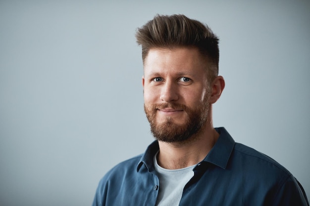 Young successful student employee or manager in casual shirt looking at camera