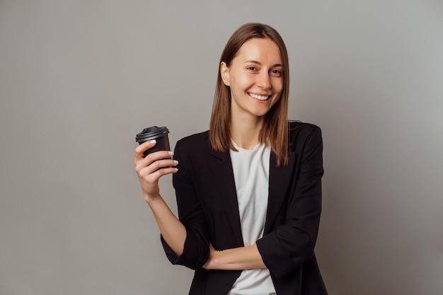 Young successful woman is taking a break from work and drinks a little coffee