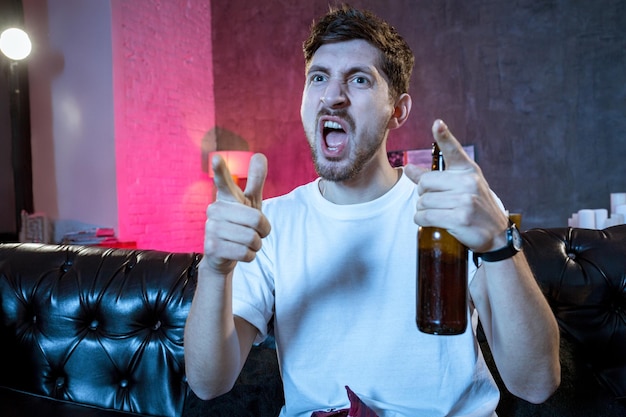 Photo young supporter man watching football game on television sitting