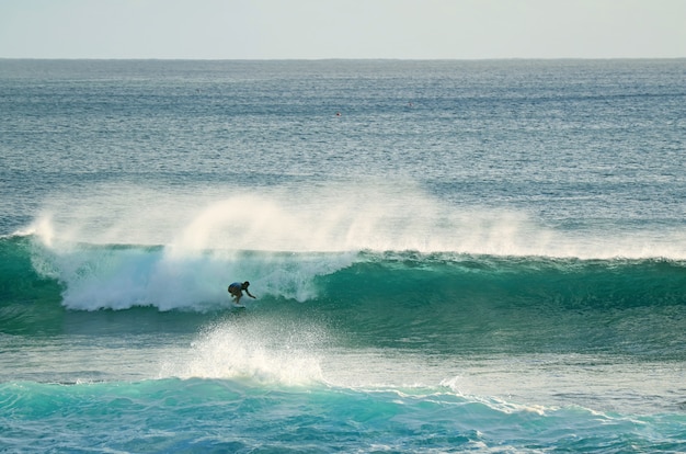 Young surfer riding on breaking waves