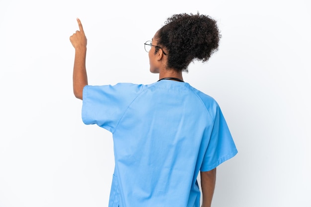 Young surgeon African American doctor woman isolated on white background pointing back with the index finger