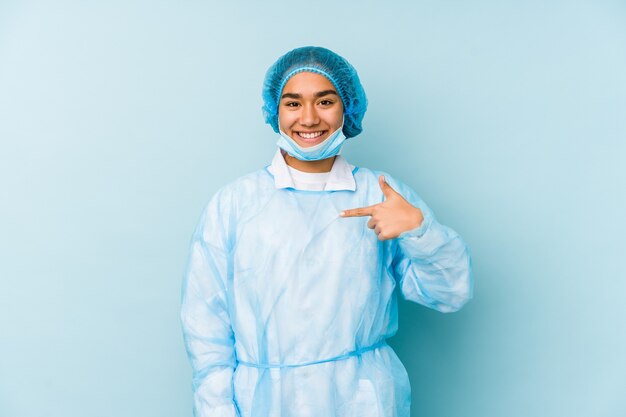 Young surgeon asian woman isolated person pointing by hand to a shirt copy space, proud and confident