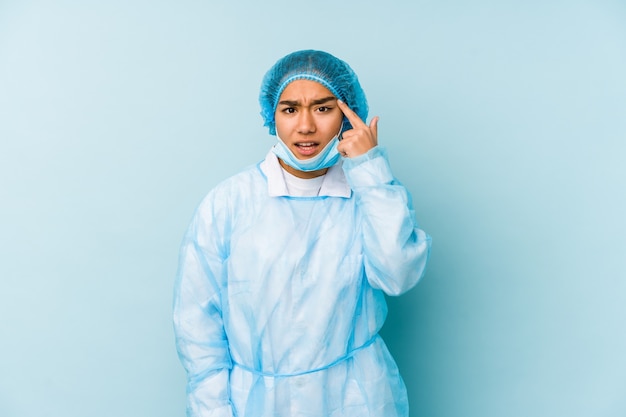 Young surgeon asian woman isolated showing a disappointment gesture with forefinger.