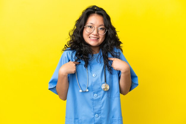 Young surgeon doctor asian woman isolated on yellow background with surprise facial expression