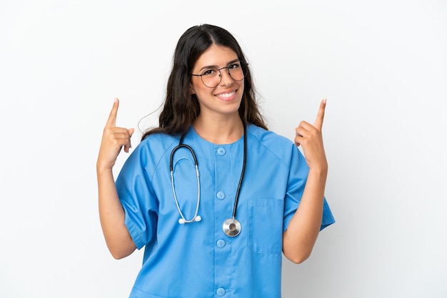 Young surgeon doctor caucasian woman isolated on white background pointing up a great idea