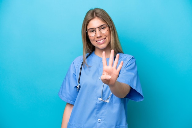 Foto donna giovane chirurgo medico isolata su sfondo blu felice e contando quattro con le dita