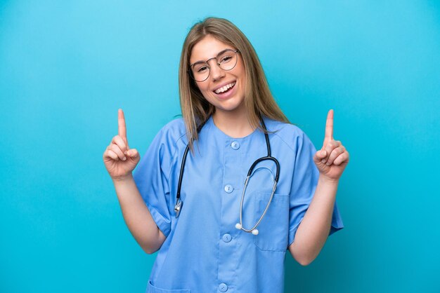 Молодая женщина-врач-хирург изолирована на синем фоне, указывая на отличную идею