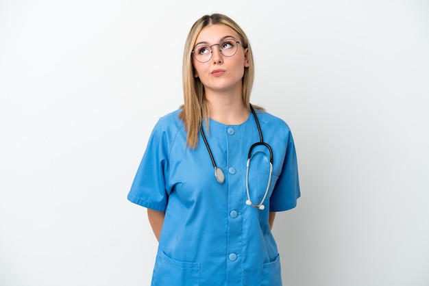 Young surgeon doctor woman isolated on white background and looking up