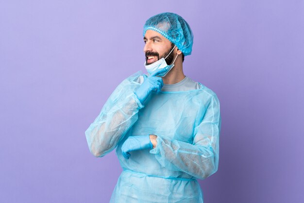 Young surgeon man over isolated wall