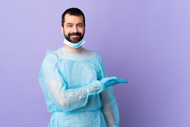 Young surgeon man over isolated wall