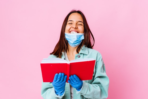 Young surgeon woman reading a book isolated