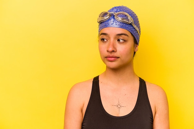 Young swimmer hispanic woman isolated on yellow background