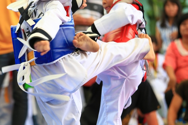 I giovani atleti di taekwondo stanno combattendo durante il concorso