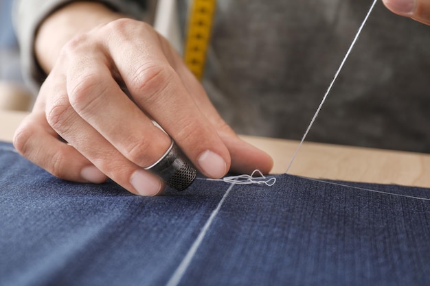 Photo young tailor working with textile closeup