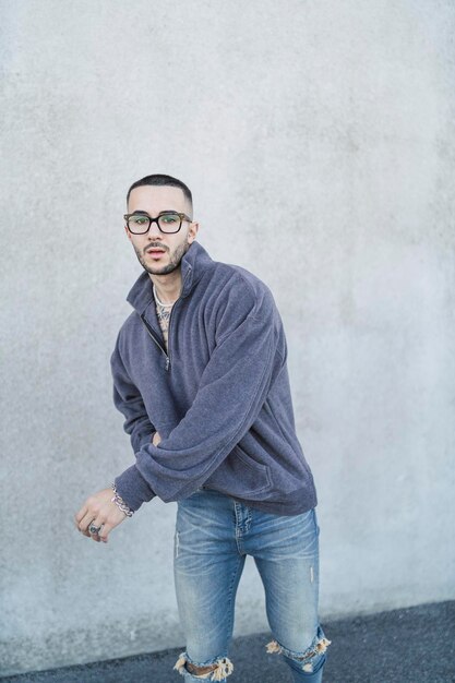 Photo young tattoed man possing in the street with urban wear