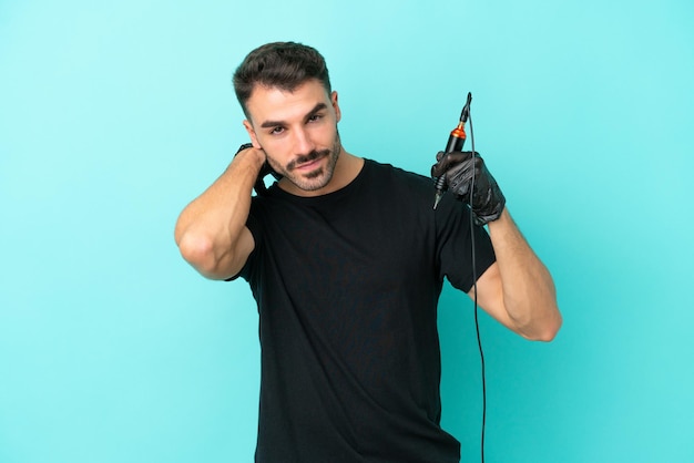 Young tattoo artist man isolated on blue background laughing