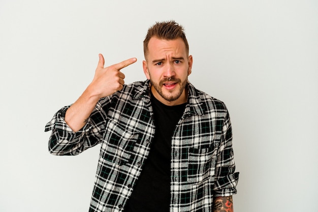 Young tattooed caucasian man isolated on white background showing a disappointment gesture with forefinger.