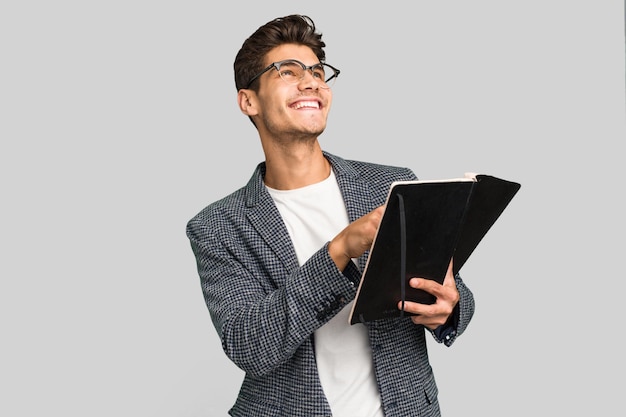 Young teacher caucasian man holding a book isolated