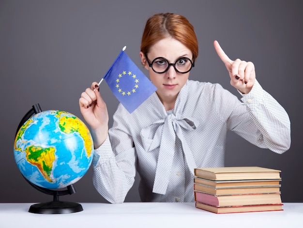 The young teacher in glasses with books