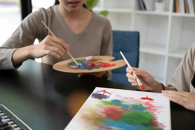 Giovane insegnante che dipinge immagini con una bambina in classe d'arte