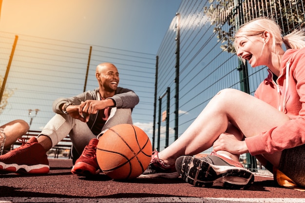 Photo young team. basketball ball lying near a happy young girl talking to her friends